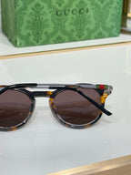 Gucci round sunglasses with dark lenses and tortoiseshell-style front frame