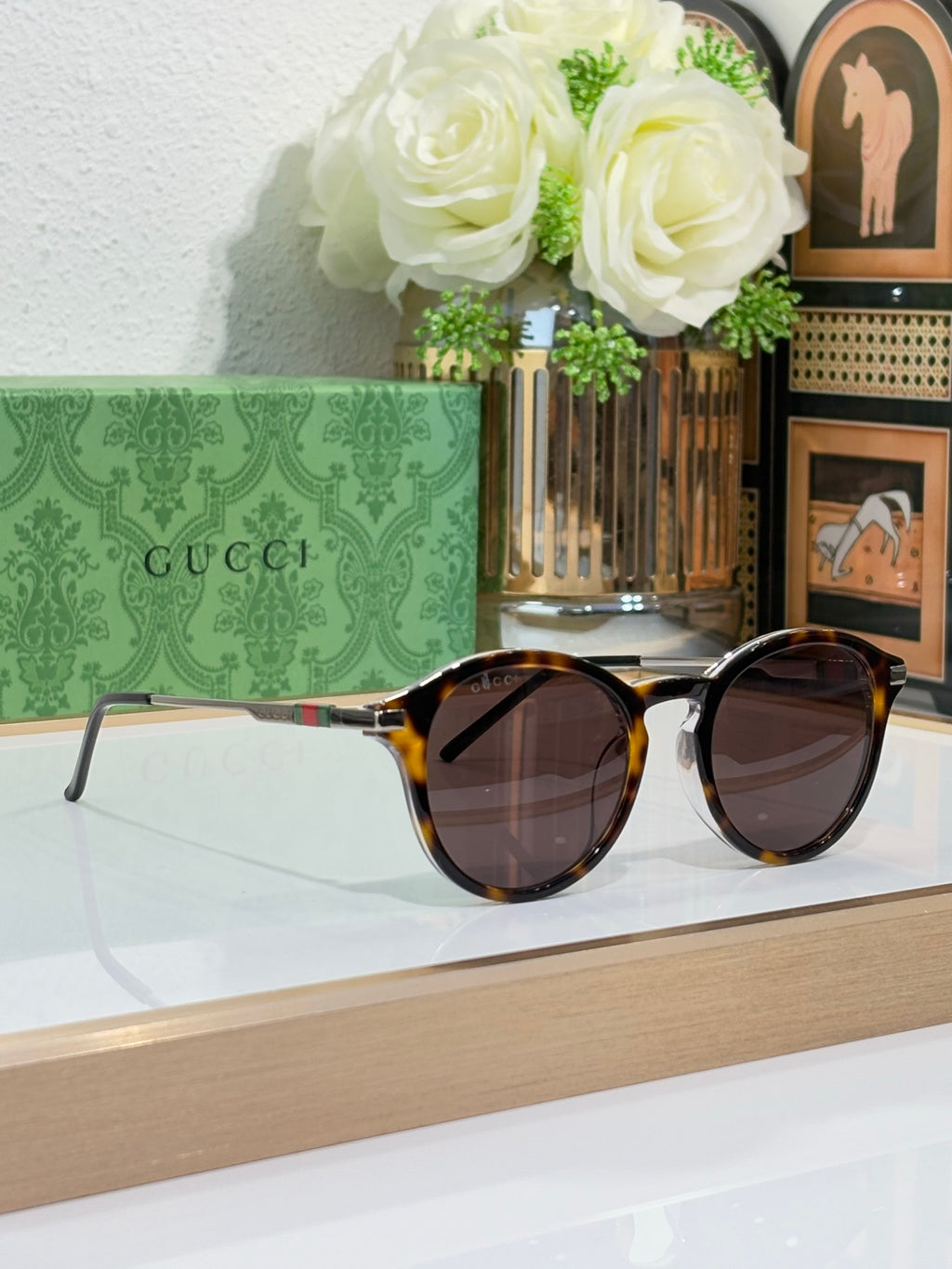 Gucci oval sunglasses with dark lenses and tortoiseshell-style frame