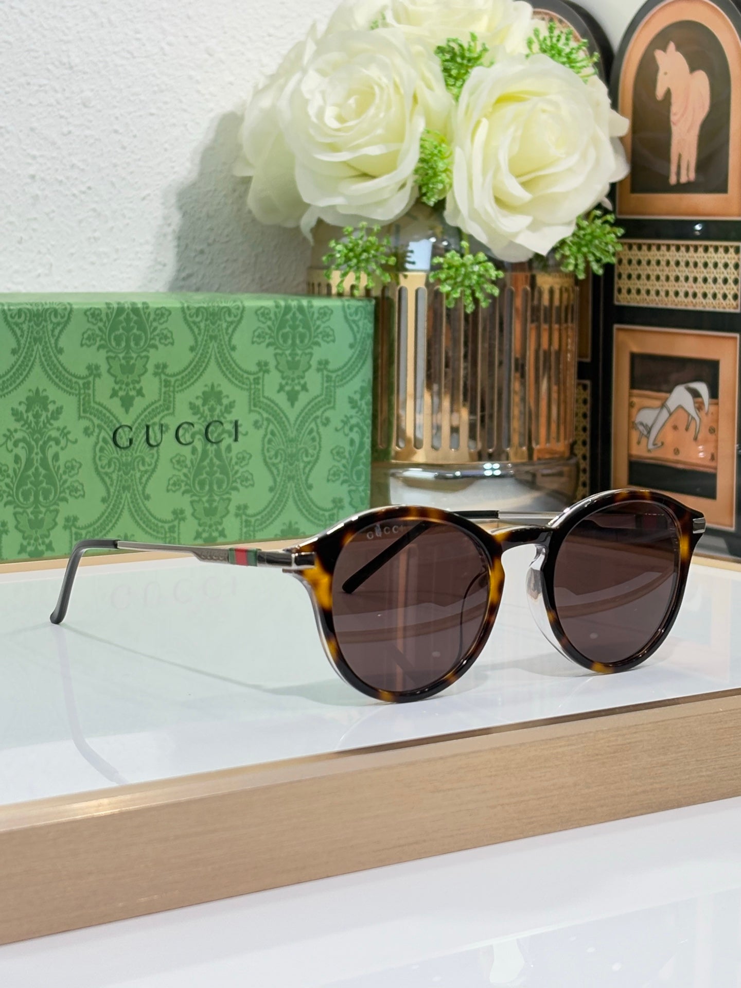 Gucci oval sunglasses with dark lenses and tortoiseshell-style frame