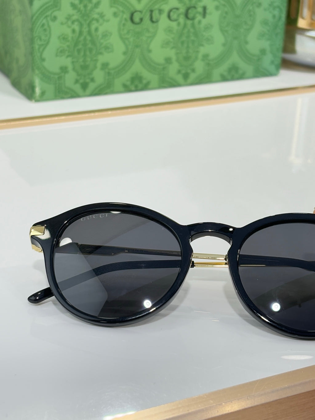 Gucci round sunglasses with dark lenses and glossy black full-rim frame