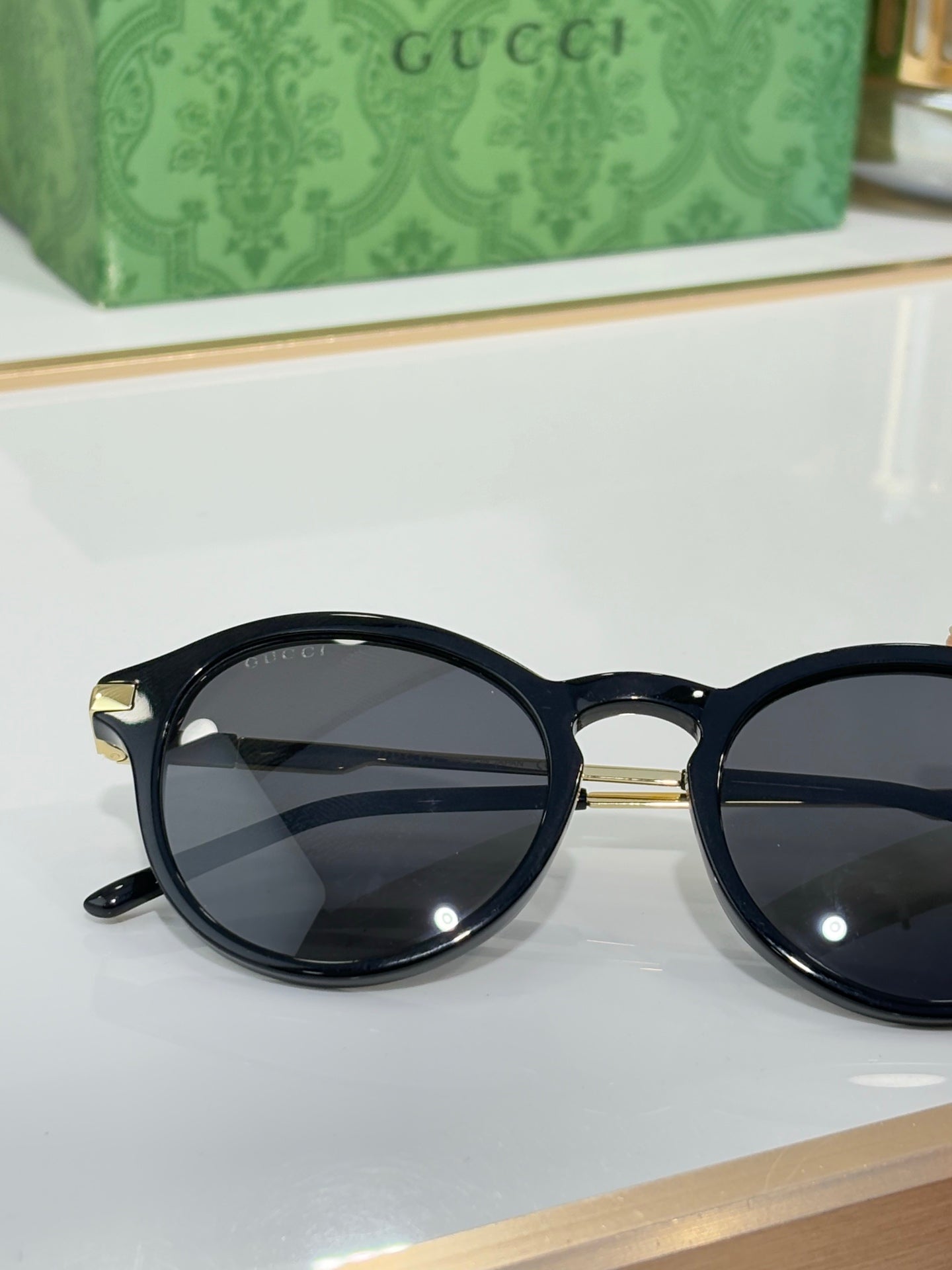 Gucci round sunglasses with dark lenses and glossy black full-rim frame