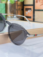 Gucci round sunglasses with dark lenses and smoky gray frame with metal arm