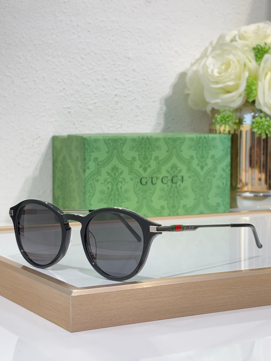 Gucci round sunglasses with dark lenses and black frame with metal temples