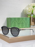 Gucci round sunglasses with dark lenses and black frame with metal temples