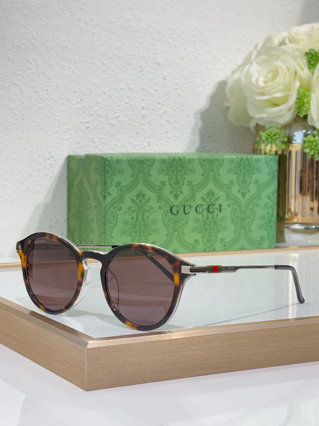 Gucci round sunglasses with dark lenses and tortoiseshell-style accents on frame