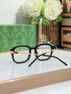 Gucci eyeglasses angled on display with dark frames and clear lenses