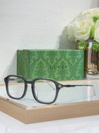 Gucci eyeglasses with dark rounded frames and clear lenses, Gucci logo on temple