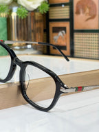 Gucci eyeglasses side view with dark frames, clear lenses, striped temple detail