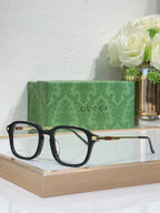 Gucci eyeglasses with dark frames and tortoise-tone top rims, clear lenses