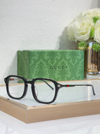 Gucci eyeglasses with dark rounded frames and clear lenses, slim temple with stripe