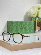 Gucci eyeglasses with dark frames and tortoise-tone accents, clear lenses