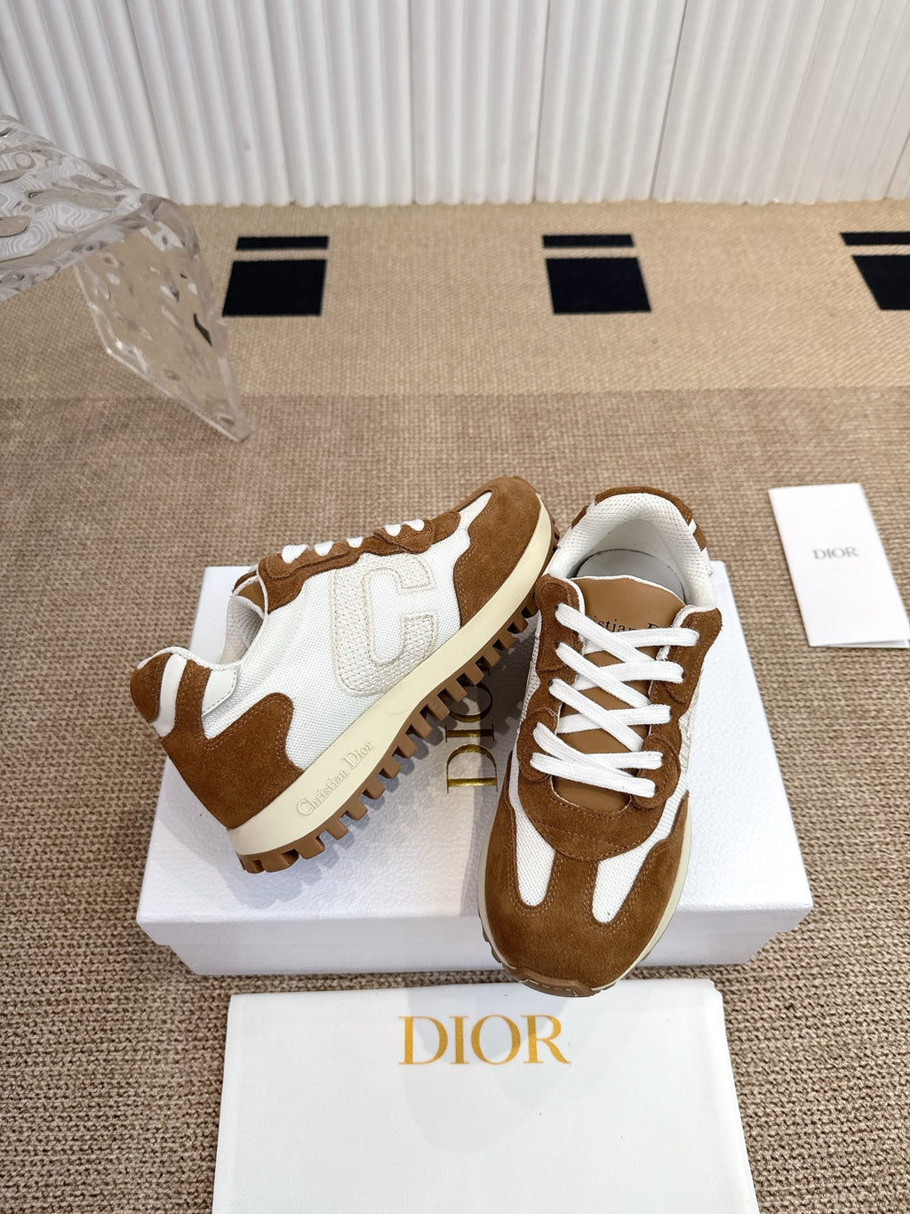 Dior unisex sneakers on white box, white laces and brown suede with cream sole.