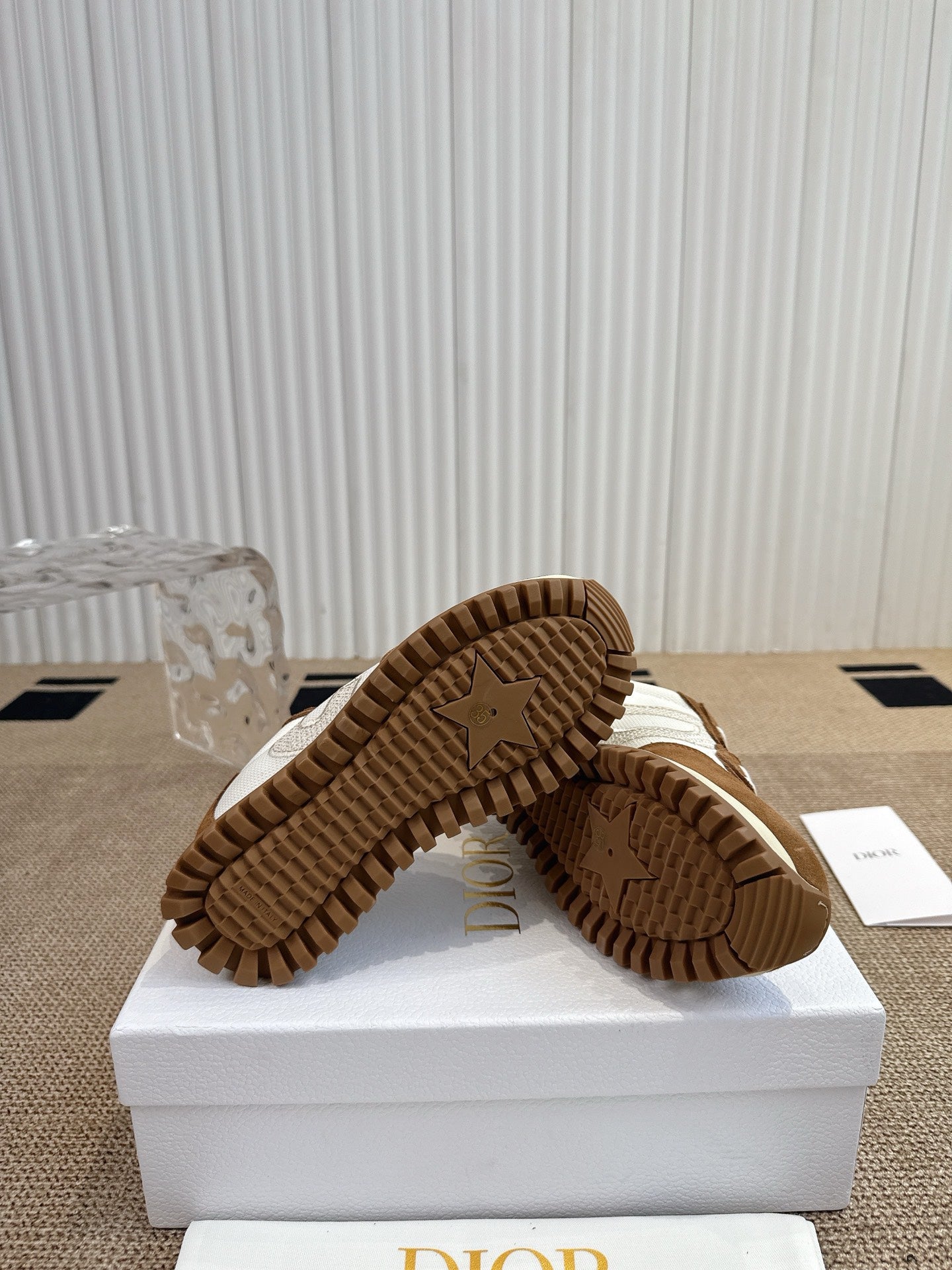 Dior unisex sneakers outsole view, brown tread and ribbed rubber sole.