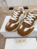 Dior unisex sneakers close-up, brown suede with white laces and padded tongue.