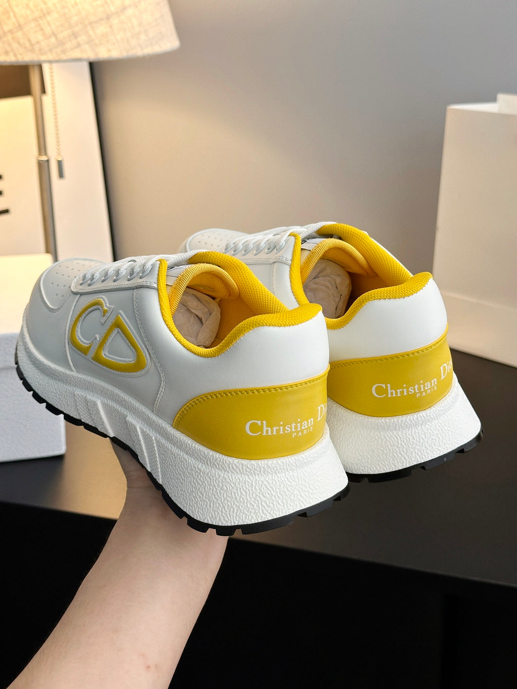 White sneakers with yellow heel lining and printed logo on the back