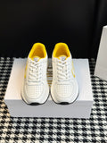 Pair of white low-top sneakers with yellow lining and white lace-up closure