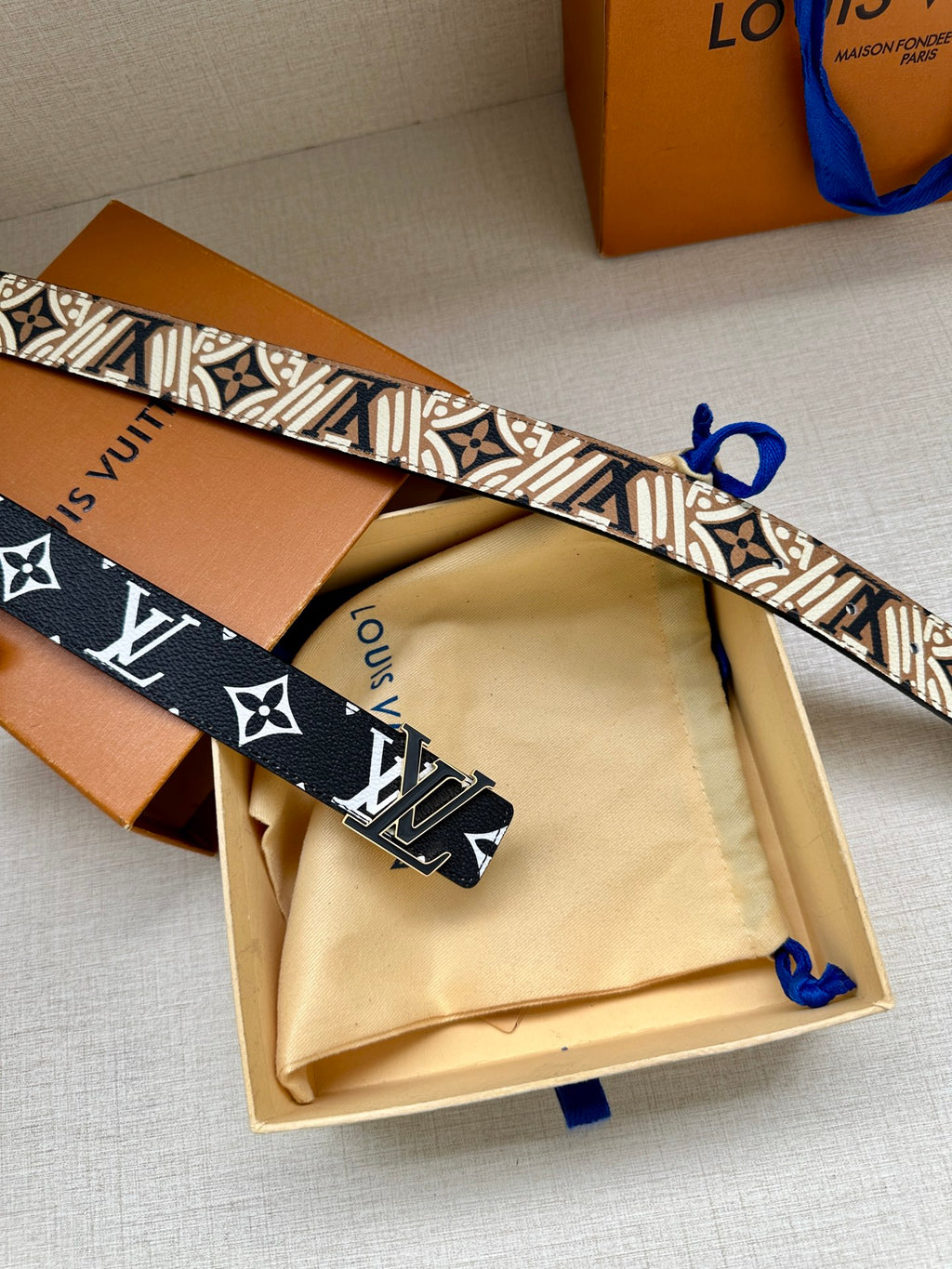 Louis Vuitton belt with dark blue monogram strap and white LV and flower motifs