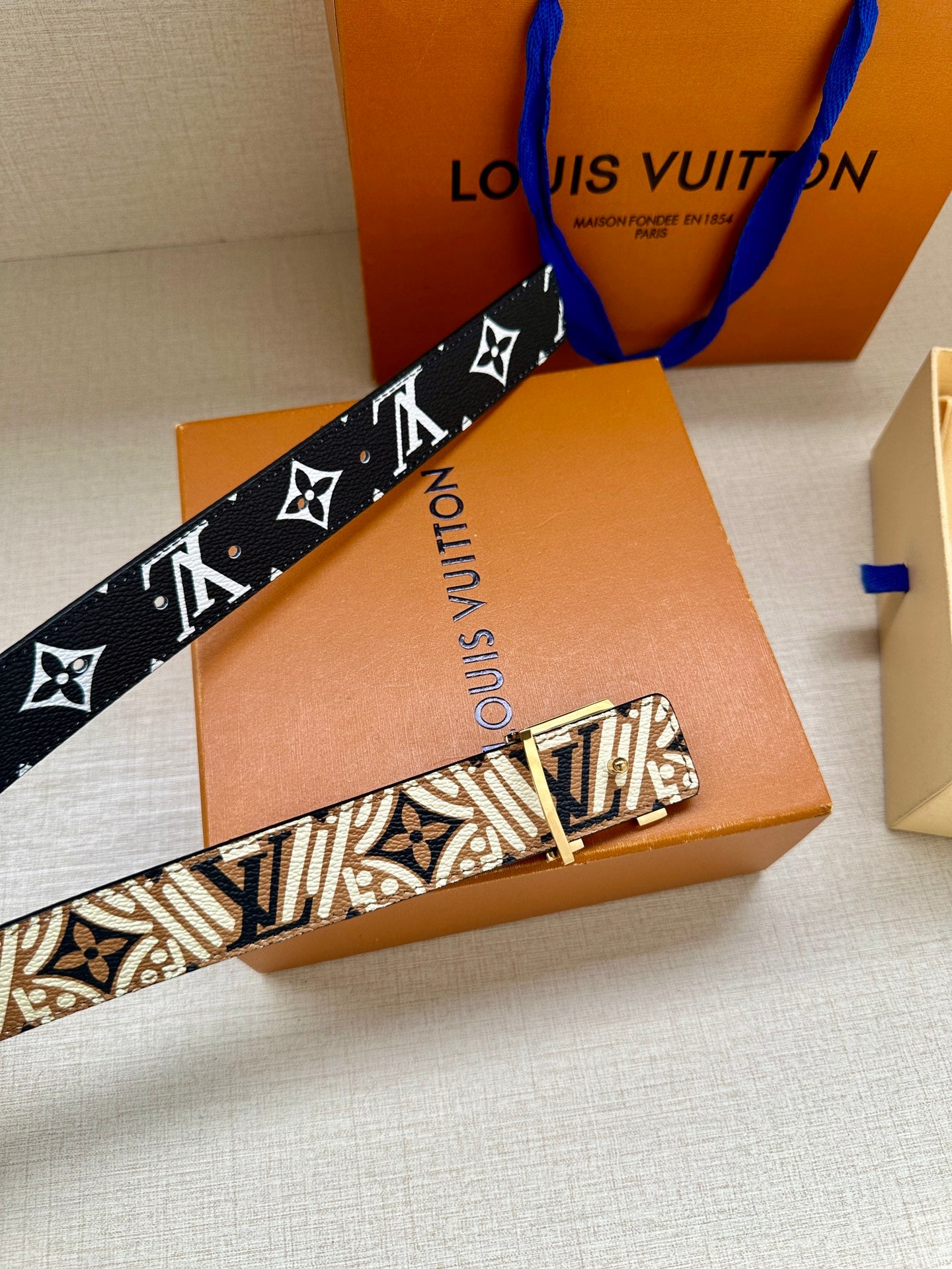 Louis Vuitton belt featuring a dark blue monogram strap with wide silver buckle