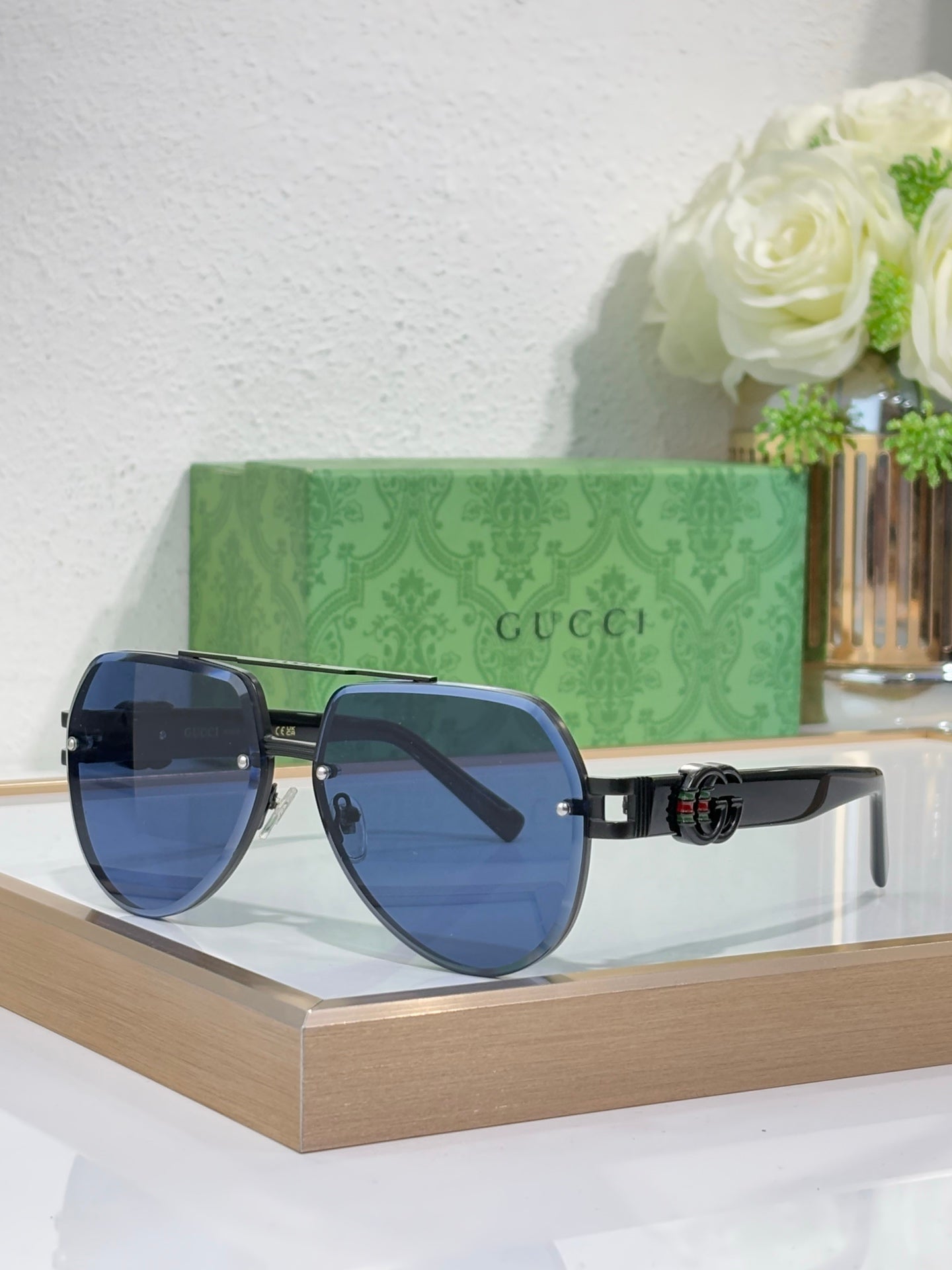 Gucci sunglasses with gold-tone frames and blue gradient lenses