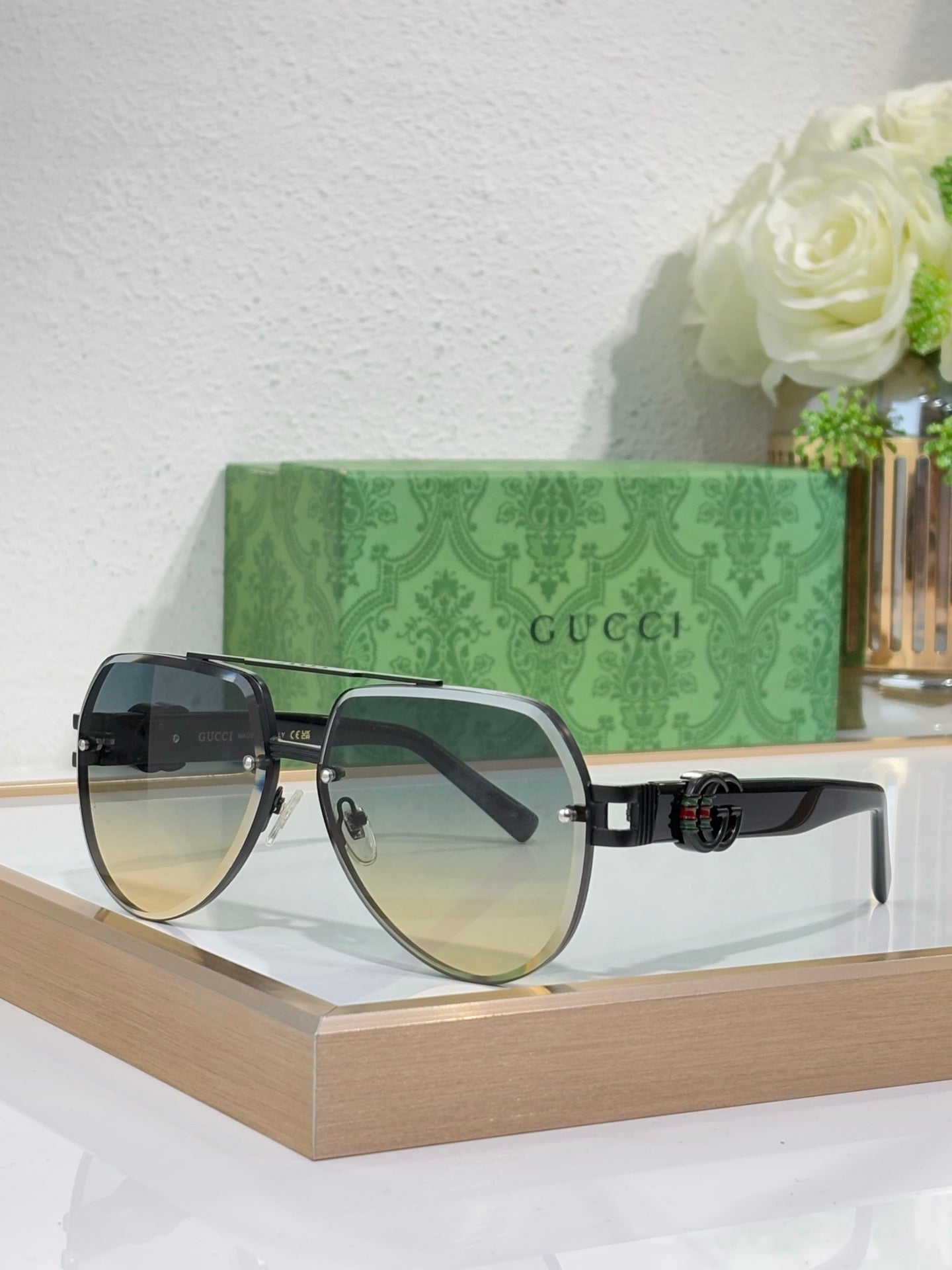 Gucci sunglasses with gold-tone frames and black-to-blue gradient lenses