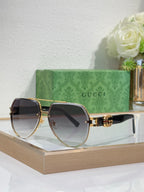 Gucci sunglasses with gold-tone frames and dark gradient lenses