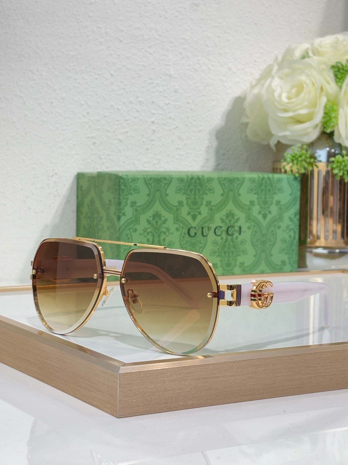 Gucci sunglasses with gold-tone frames and brown gradient lenses