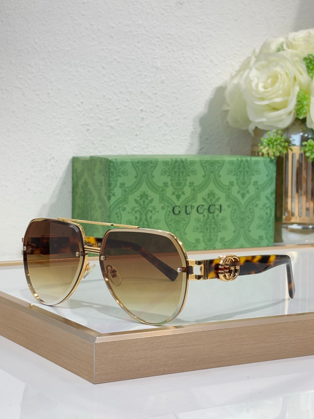 Gucci sunglasses with gold-tone frames and amber gradient lenses