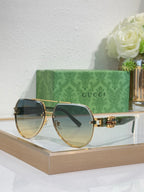 Gucci sunglasses with gold-tone frames and dark smoky lenses