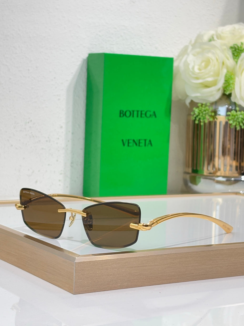 Sunglasses with gold frame and dark olive-brown lenses, front view