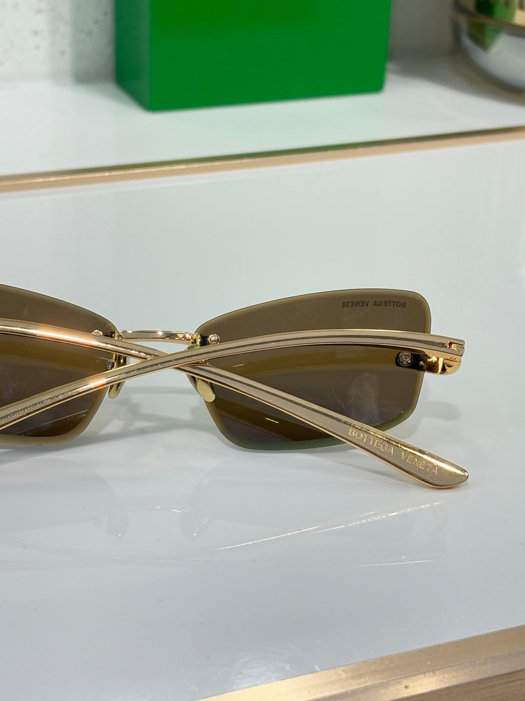 Sunglasses close-up with brown lenses and gold crossbar bridge