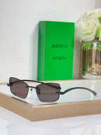 Sunglasses with dark frame and smoke-brown lenses, gold-tone hinge details