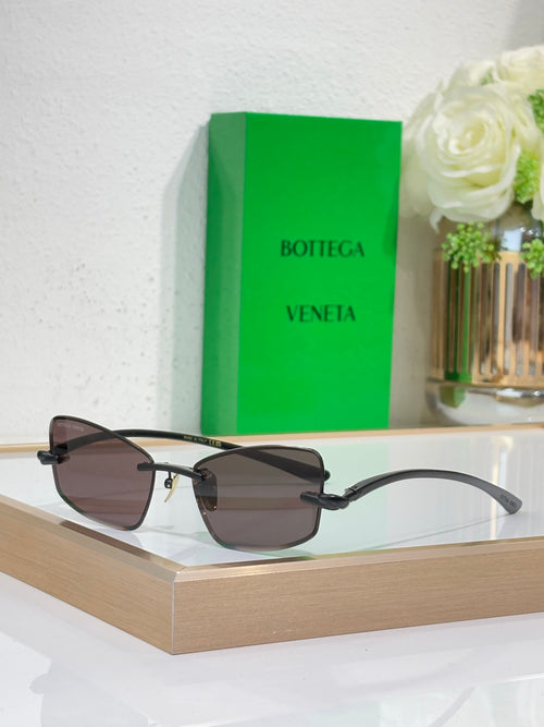 Sunglasses with dark frame and smoke-brown lenses, gold-tone hinge details