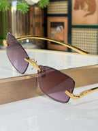 Sunglasses side view with mauve lenses and gold frame with hinge detail