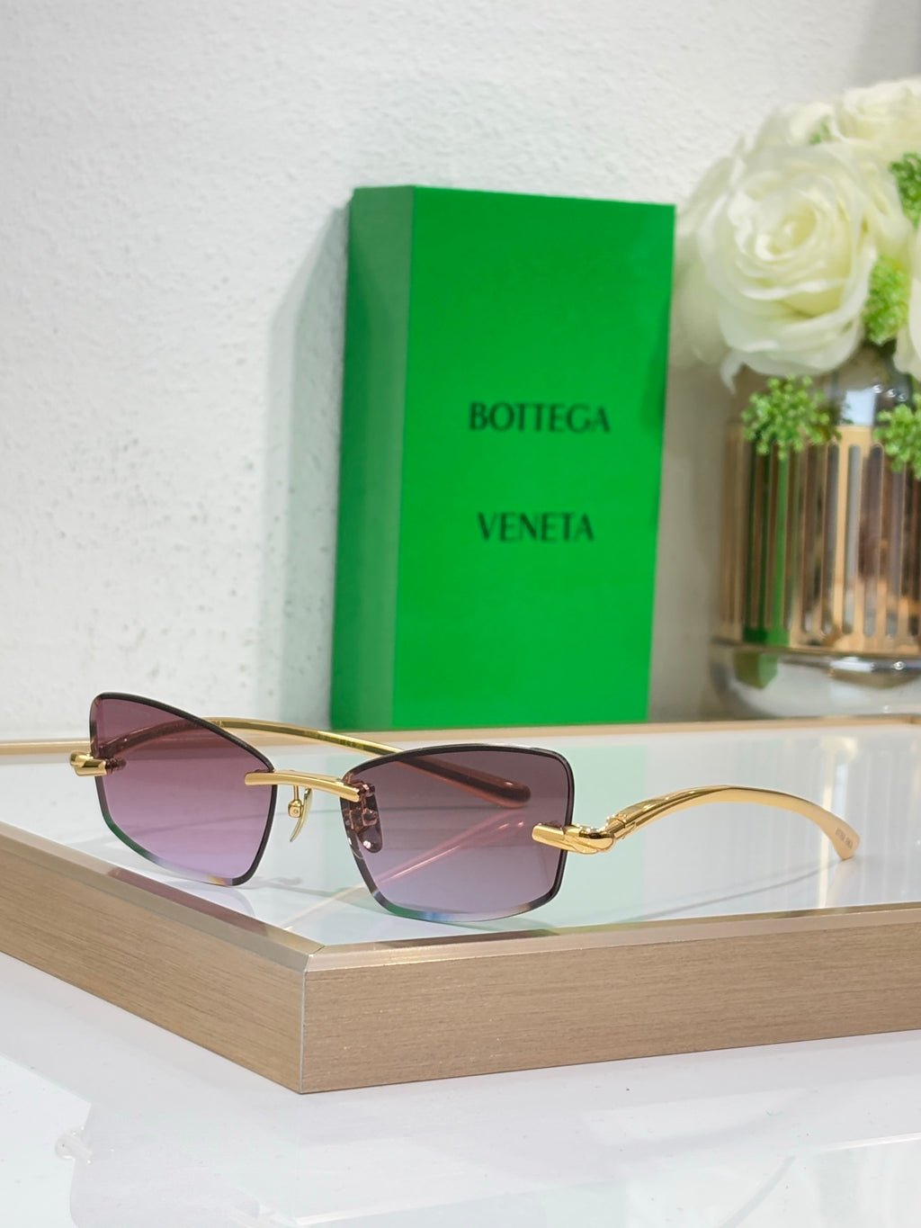 Sunglasses with gold frame and mauve lenses, front view