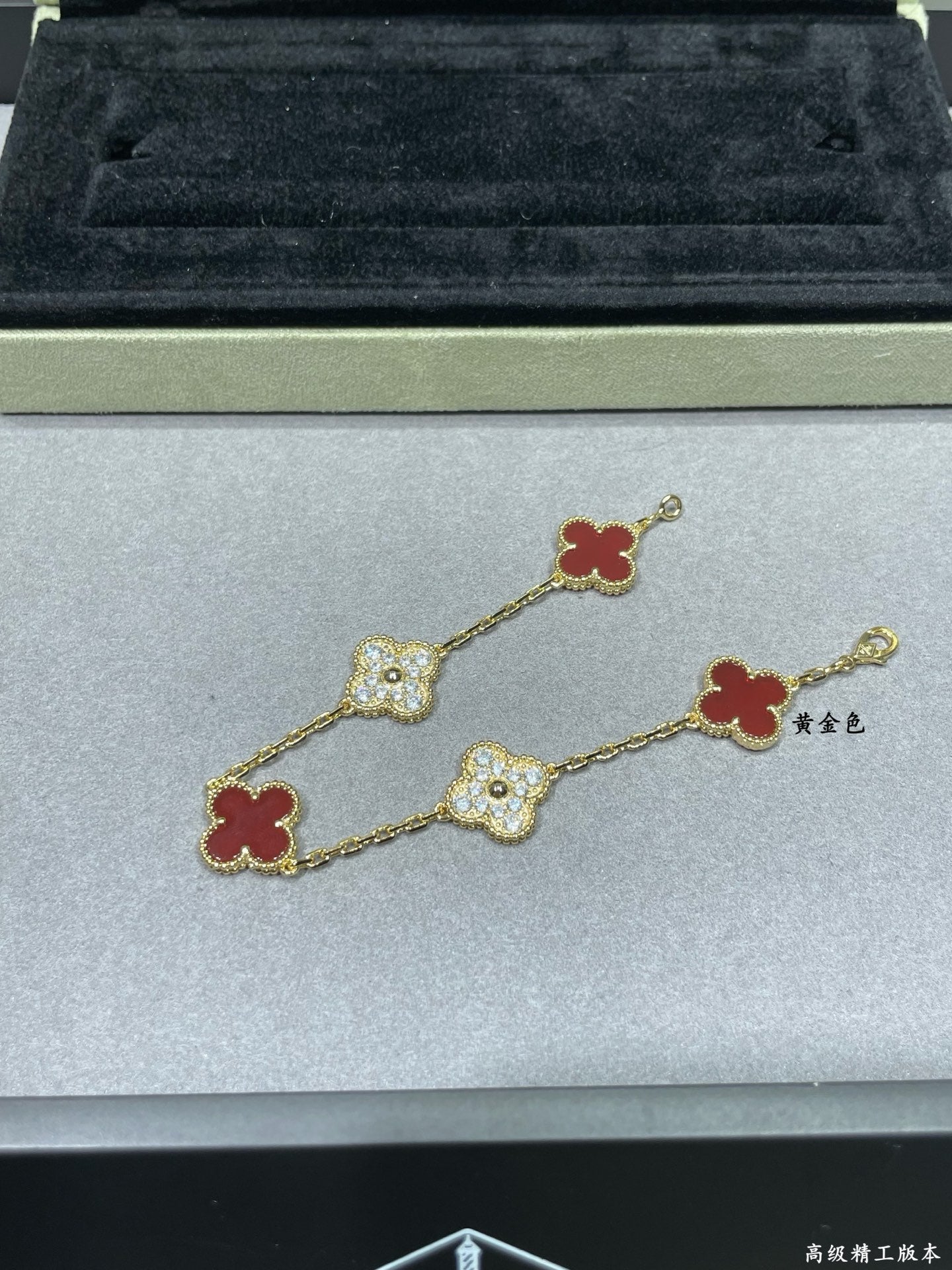 Gold-tone clover bracelet with red enamel and pavé quatrefoil charms
