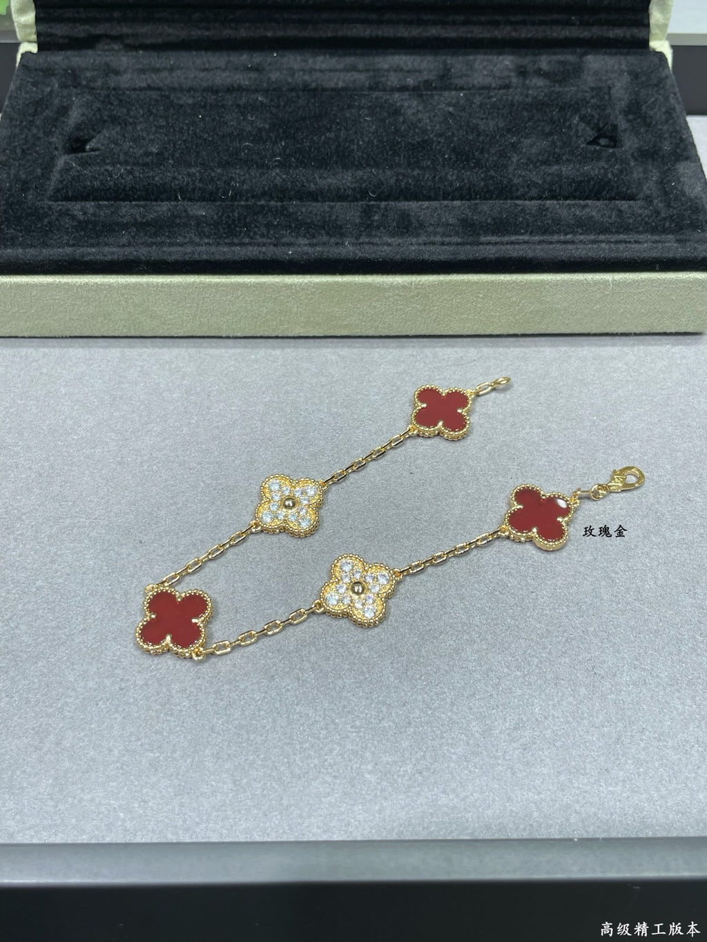 Gold-tone clover bracelet with red enamel and pavé quatrefoil charms