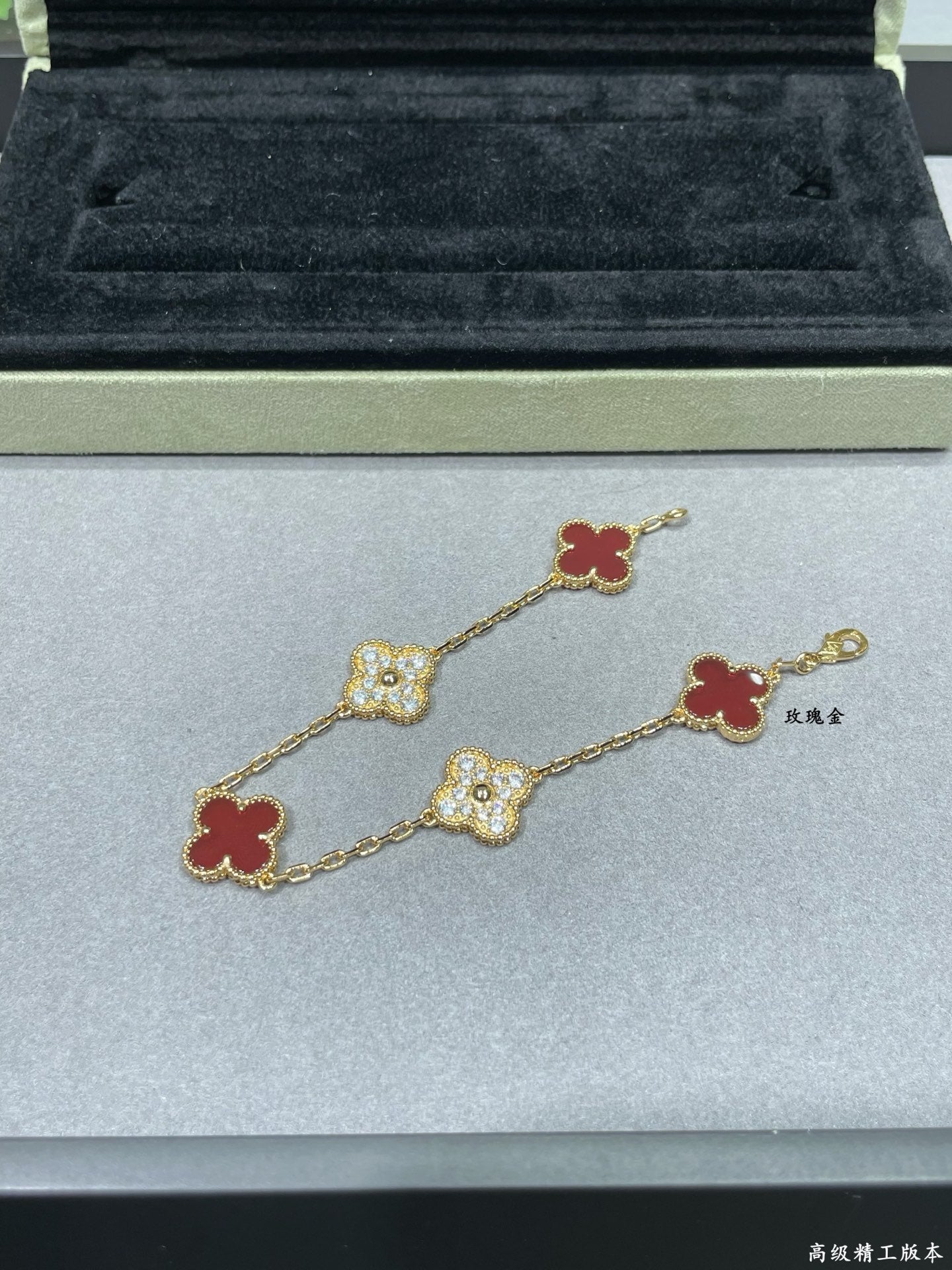 Gold-tone clover bracelet with red enamel and pavé quatrefoil charms