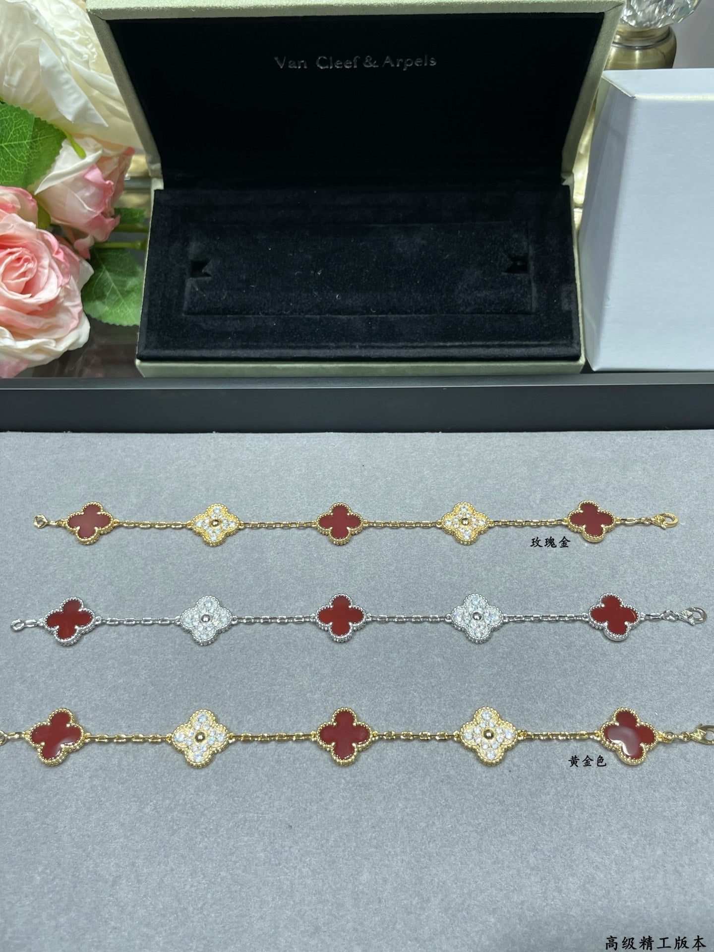 Clover charm bracelet set with red enamel and pavé links on display