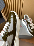 Prada unisex sneaker close-up, olive green glossy leather with white lace eyelets