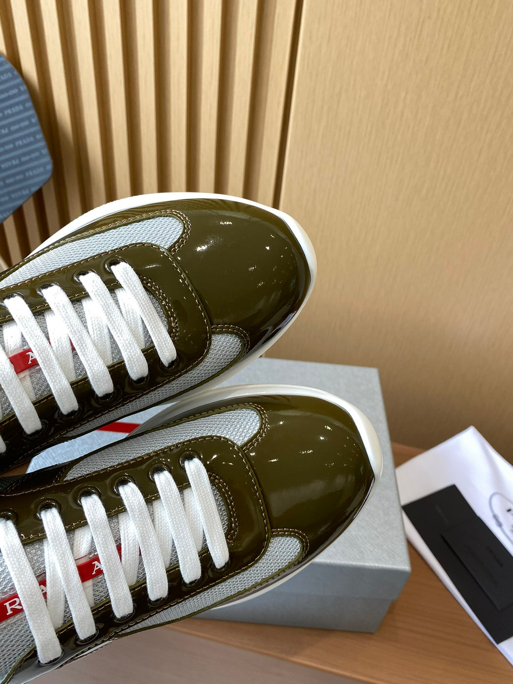 Prada unisex sneaker toe view, olive green patent leather with white laces
