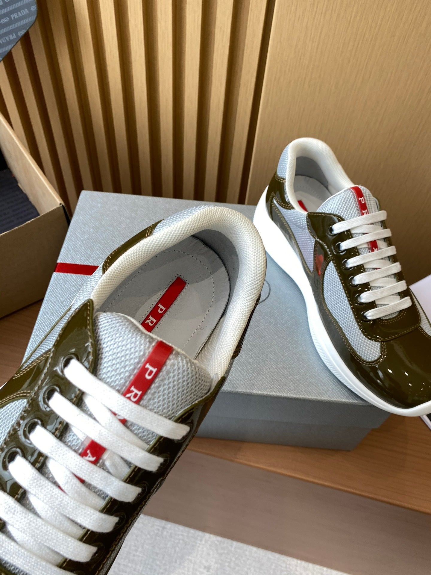 Prada unisex sneakers heel view, white lining and tongue label with red accents