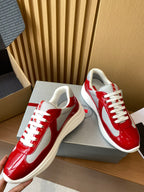 Prada unisex sneakers with red glossy leather, white sole, and white lace-up eyelets