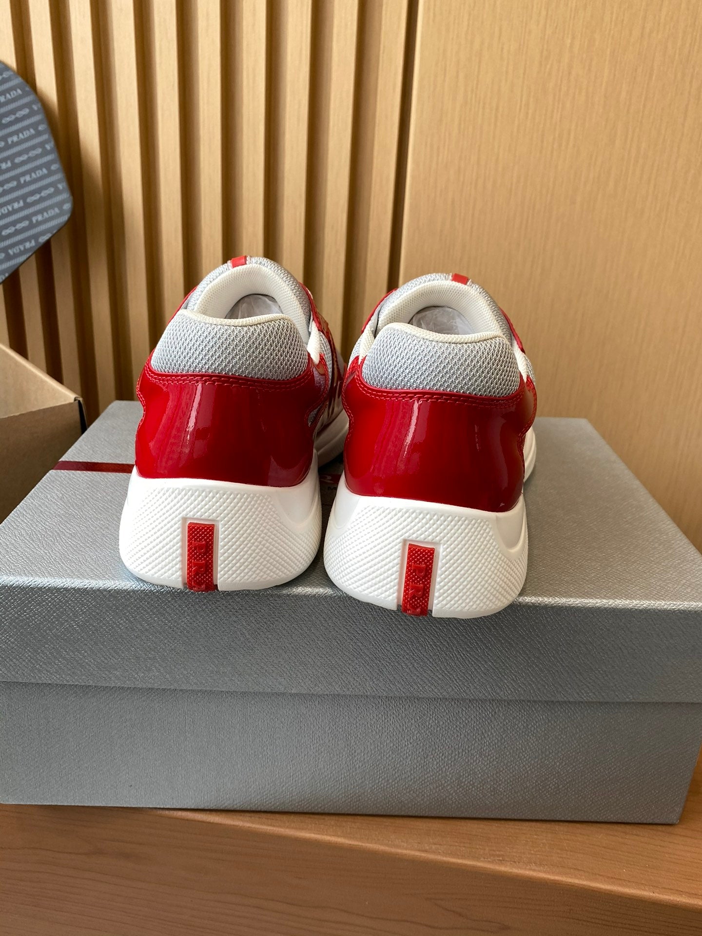 Prada unisex sneakers with red heel and white block sole, rear view