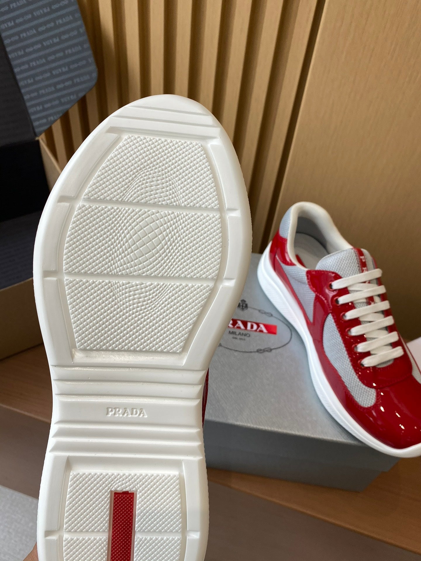 Prada unisex sneakers outsole showing white sole with red-and-white upper