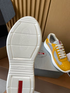 Prada unisex sneakers outsole view with white tread and yellow-and-gray upper