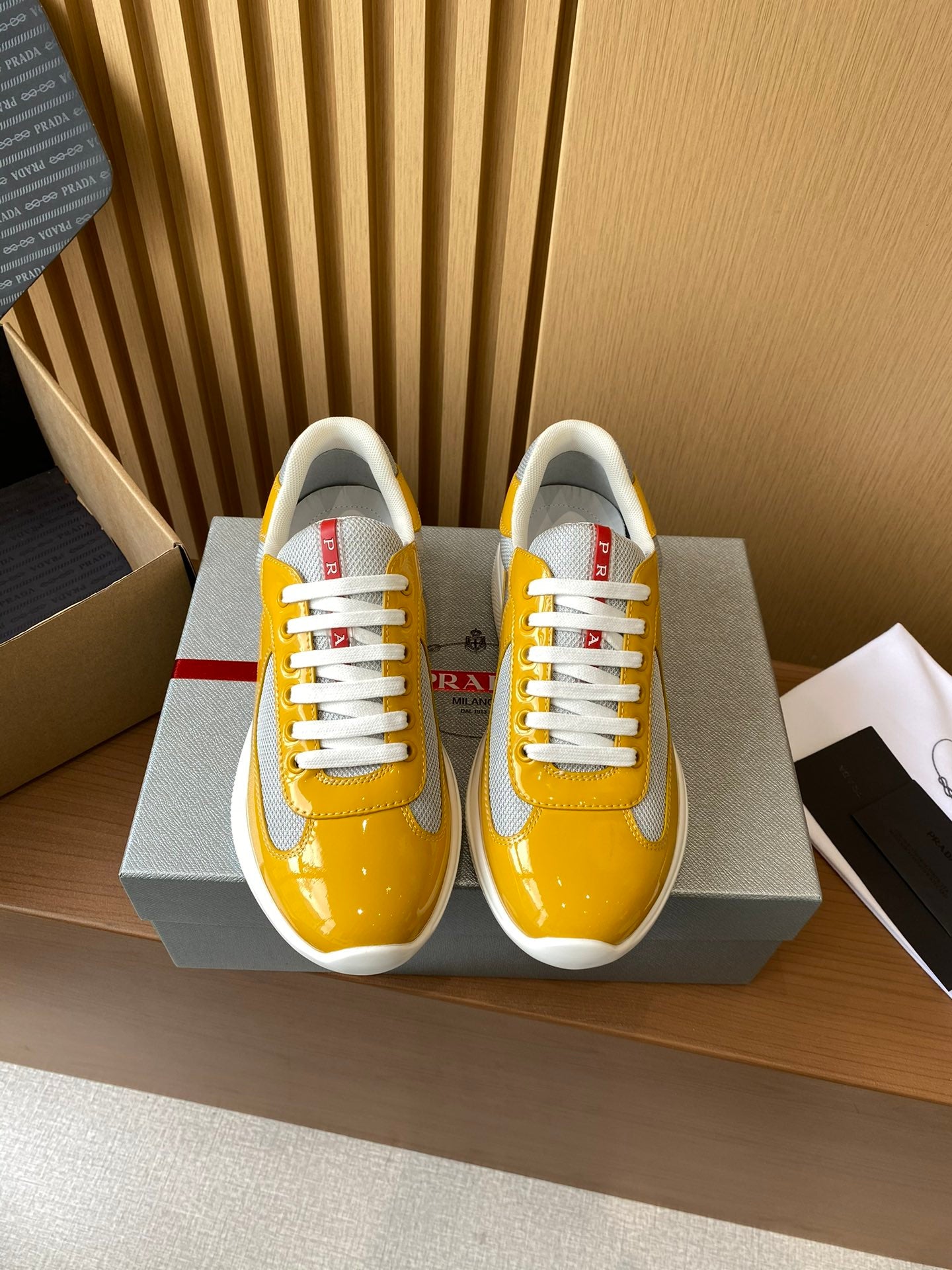 Prada unisex sneakers, yellow and gray with white laces and red heel accents