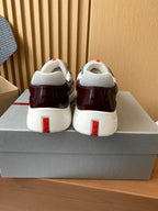 Pair of burgundy low-top sneakers with white heels and red vertical logo accents