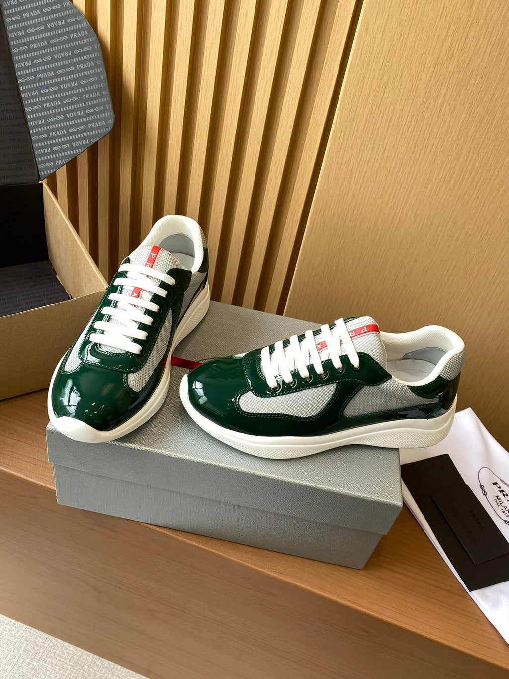 Prada unisex green sneakers on box, angled view, white rubber sole