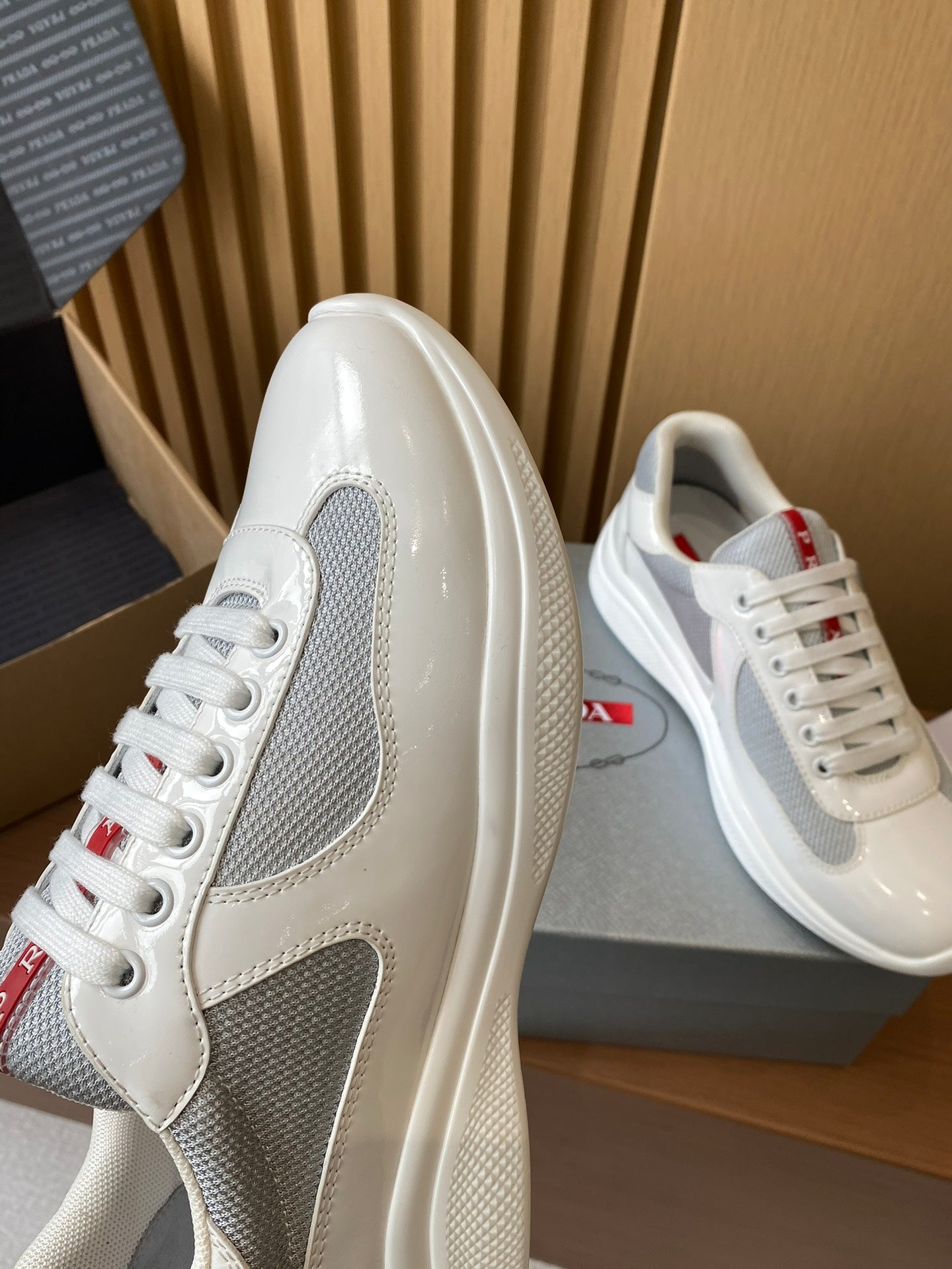Prada unisex white sneakers with gray side panel, glossy leather, lace-up