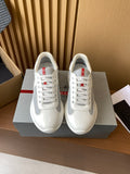 Prada unisex white sneakers, red accent lace eyelets, lace-up front view